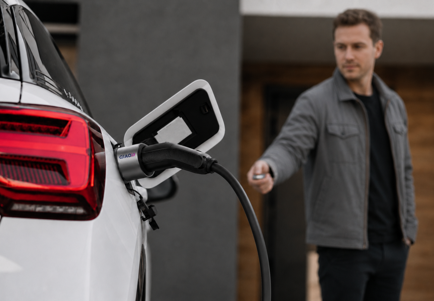 Man charging an electric car with a QIAO Q6 EV charger.